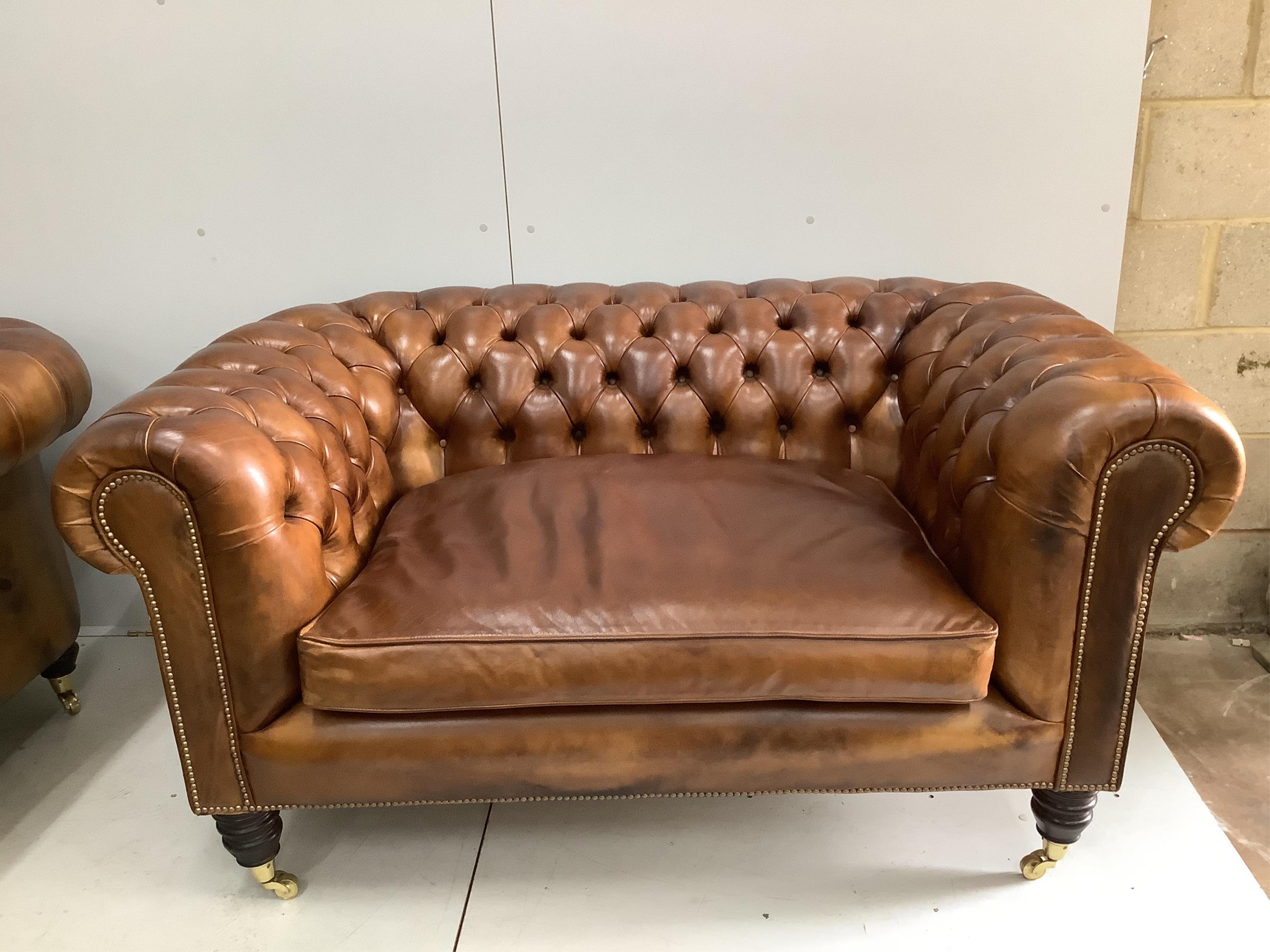 A pair of modern Victorian style buttoned tan leather small Chesterfield settees, width 154cm, depth 88cm, height 78cm. Condition - good